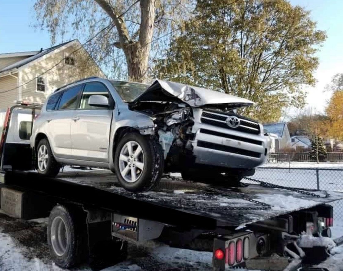 Damaged SUV secured on a flatbed tow truck