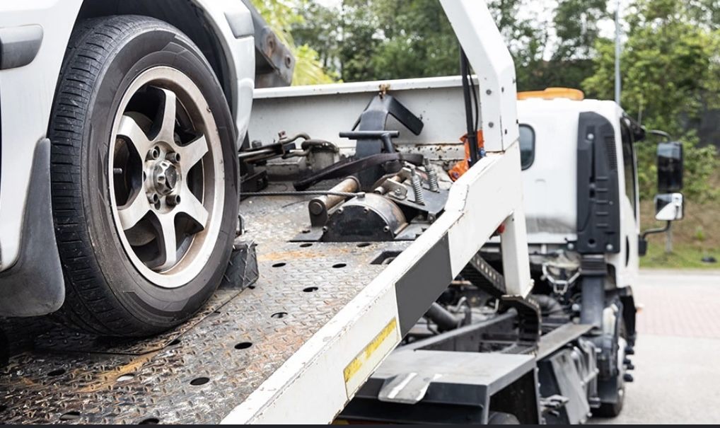 Flatbed tow truck loading a car