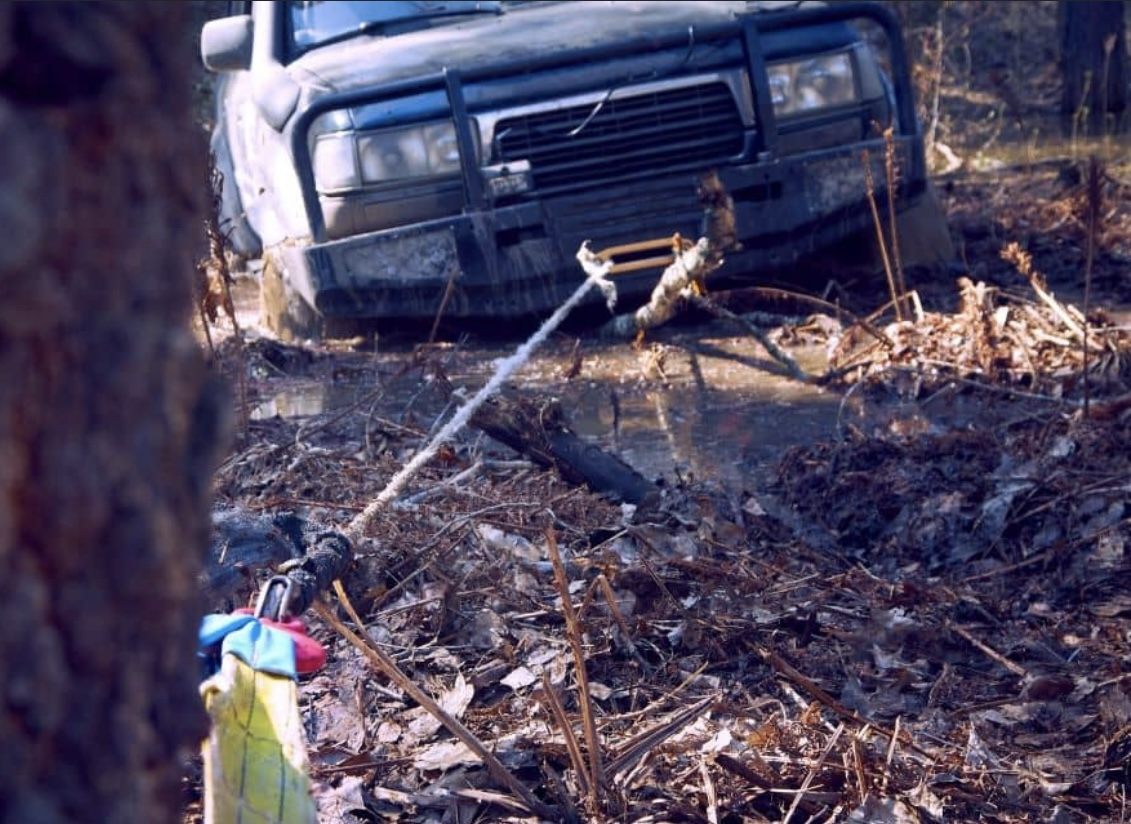 SUV being winched out of deep mud